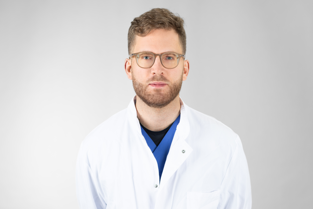 Portraitfoto von Johannes Mang: Mann mit Bart und Brille in weißem Arztkittel