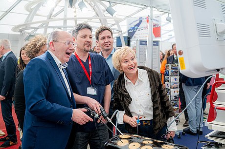 (v.l.) Christian Specht (Oberbürgermeister der Stadt Mannheim), Assistenzarzt Rasul Khasanov, Prof. Dr. med. Michael Boettcher (Direktor Kinderchirurgische Klinik UMM) und Dr. Nicole Hoffmeister-Kraut (Wirtschaftsministerin Baden-Württemberg) an dem Mitmachstand der Klinik.
