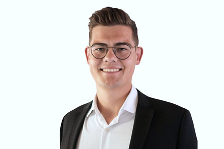 Portrait eines Mannes im weißen Hemd und dunklem Anzug vor neutralem Hintergrund
