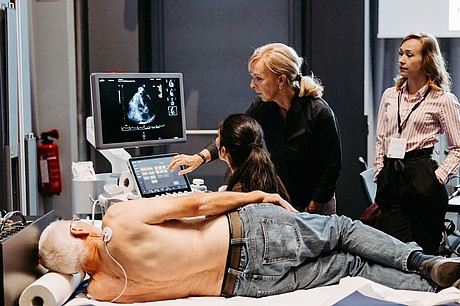 Ultraschalluntersuchung eines liegenden Probanden während eines Workshops beim ZKAM-Meeting.