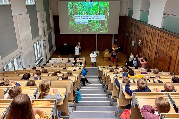 Arzt spricht vor großem Publikum in Hörsaal.