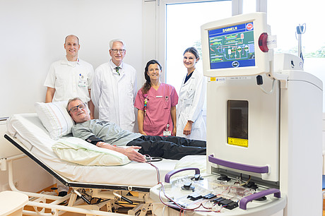 Ärzte und Medizinische Mitarbeiter*innen stehen an Krankenbett