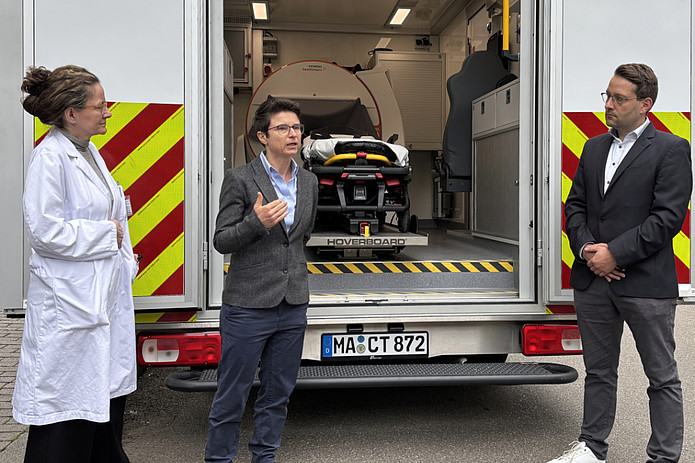 Menschen unterhalten sich vor Rettungswagen