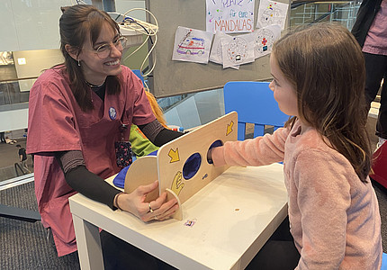 Mädchen probiert Mitmachaktion am Stand der UMM beim Neujahrsempfang aus.