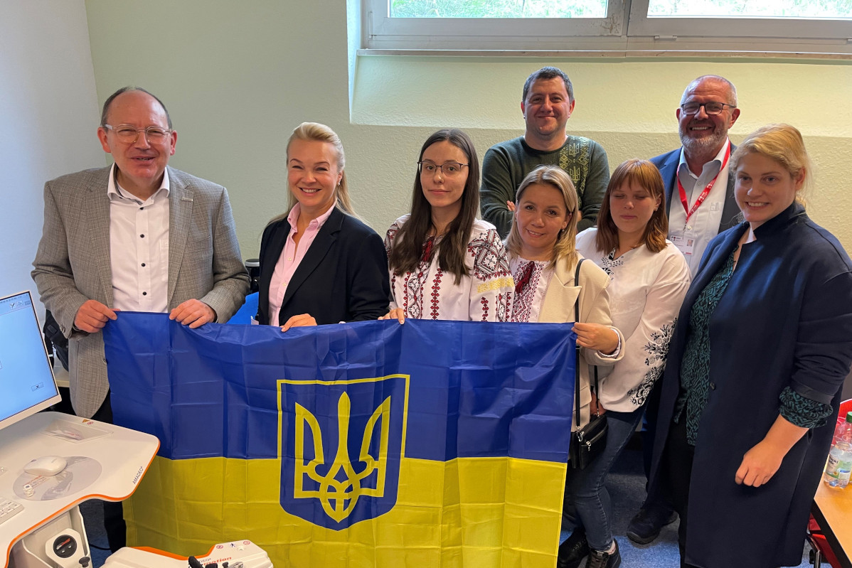 Gruppenfoto. Personen halten ukrainische Flagge vor sich.
