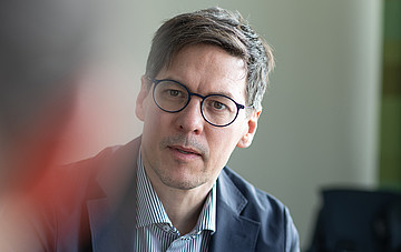 Das Bild zeigt einen attraktiven Mann in Businesskleidung mit Brille, es handelt sich um Professor Jakob, der das Verbundprojekt koordiniert