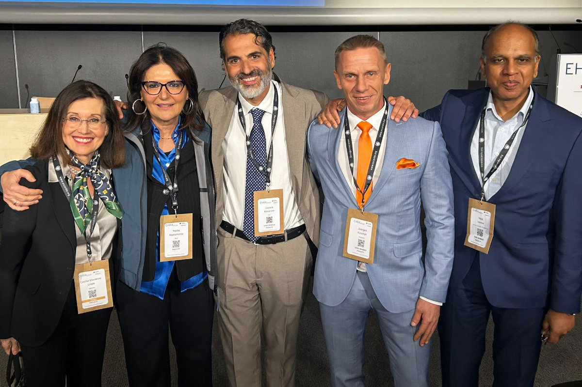 Teilnehmende stehen bei einem internationalen Fachkongress zusammen und posieren für ein Gruppenfoto.