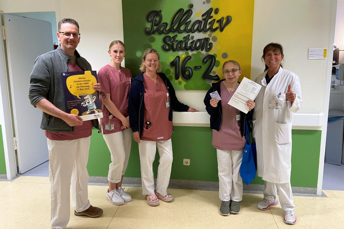 Mehrere Personen stehen gemeinsam in einem Klinikbereich und posieren für ein Gruppenfoto.