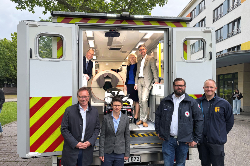 Menschen stehen vor und in Rettungswagen